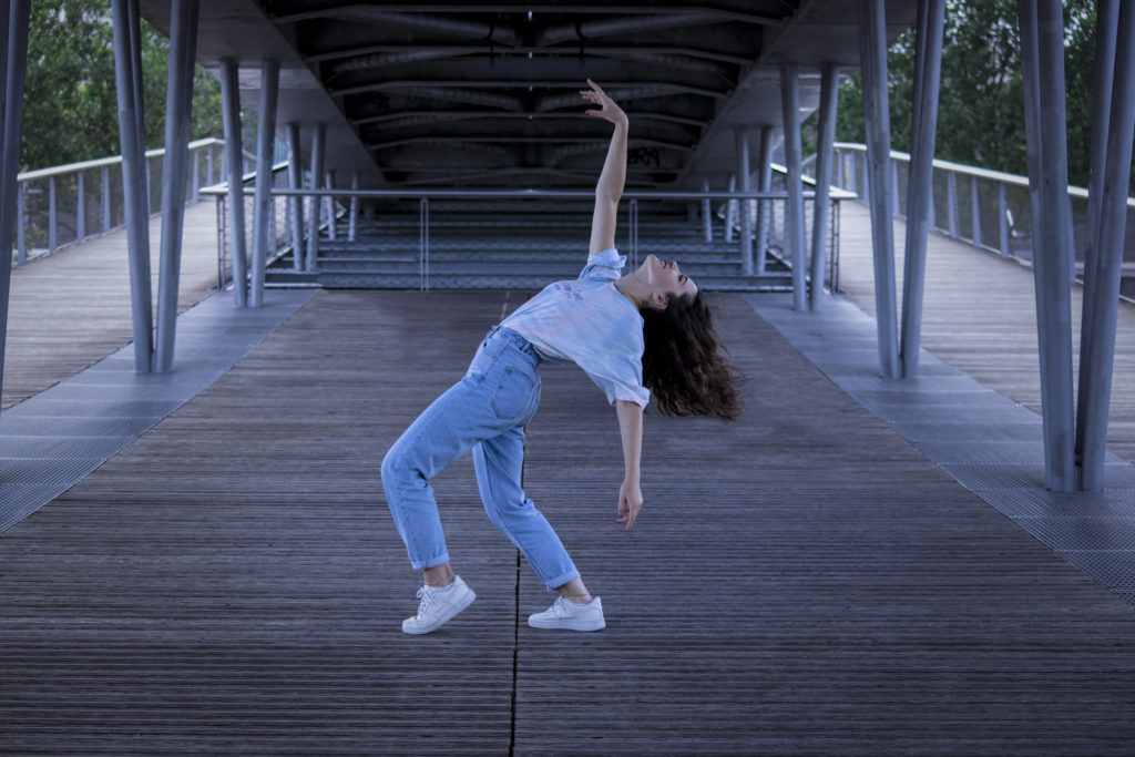 Femme avec une position de dance et main en l'air