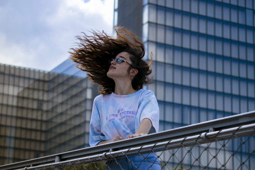 Femme sur un grillage avec cheveux au vent