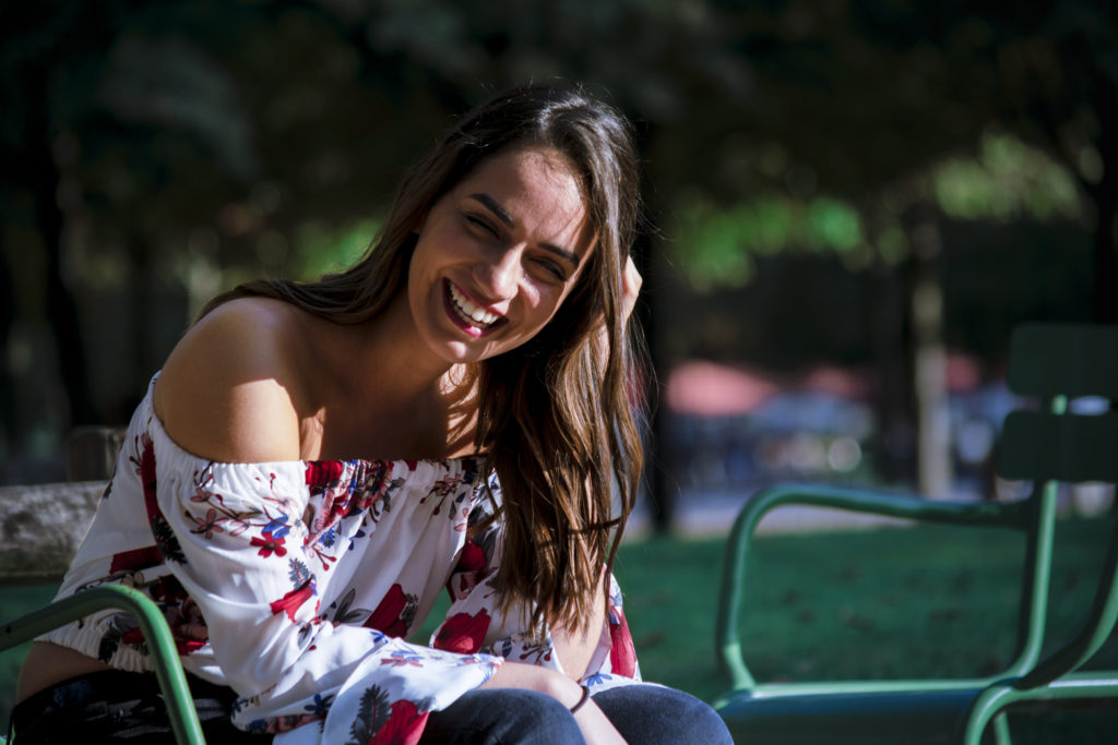 Femme avec main dans les cheveux qui rigole