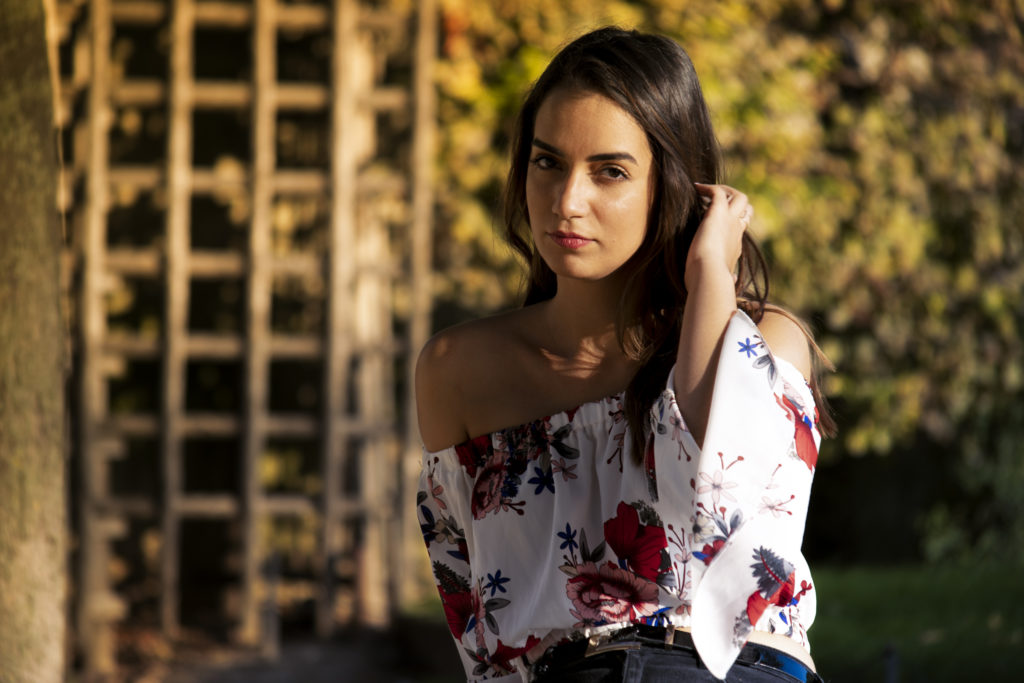 Femme brune et tenue à fleurs dans un parc