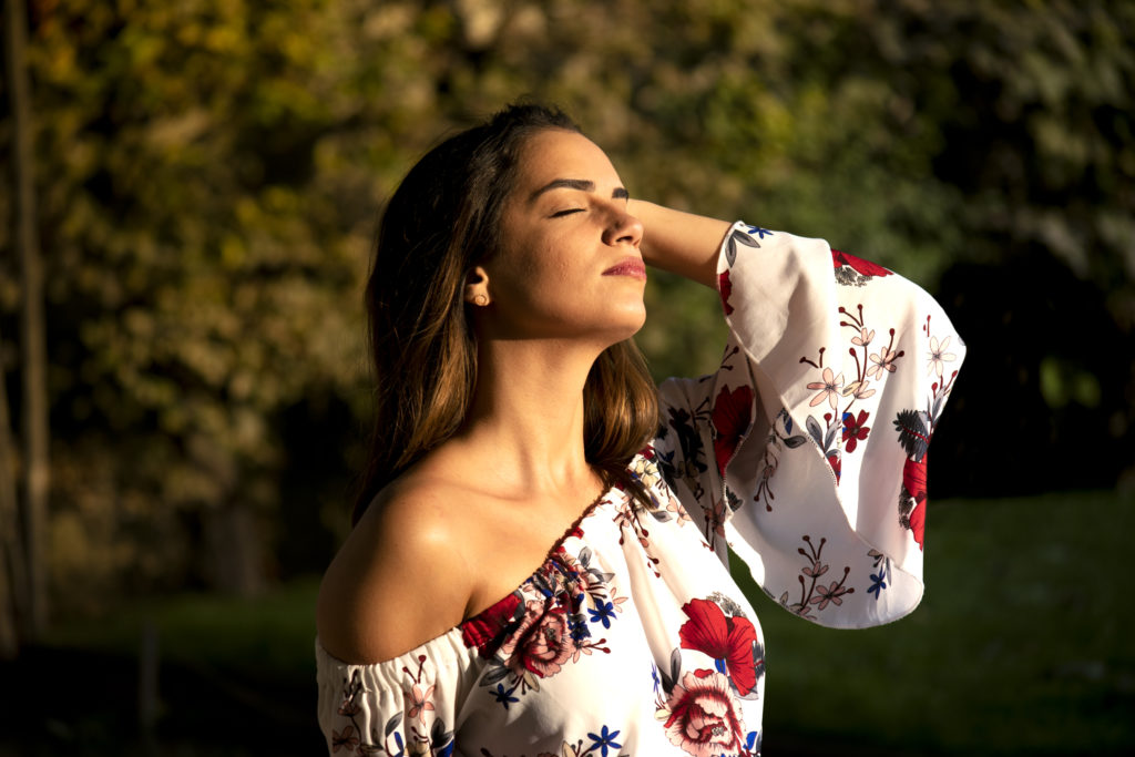 Femme brune avec soleil chaud et tenue à fleurs