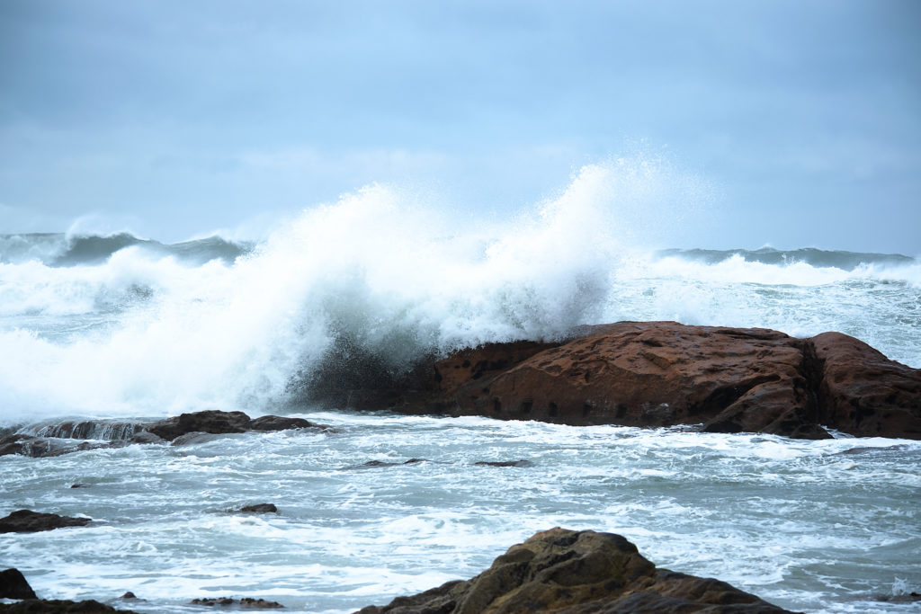 Vague déferlante sur la roche brune